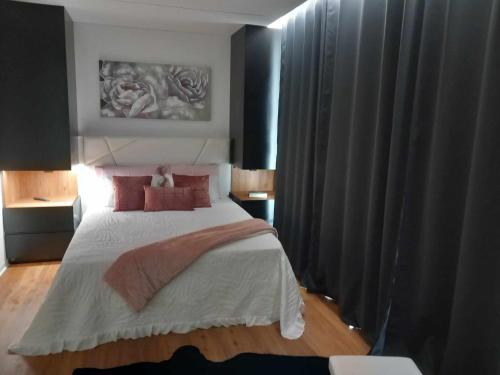 a bedroom with a large bed with red pillows at Casa de Silvares in Celorico de Basto