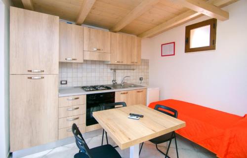 una cucina con tavolo in legno e divano rosso di Residence Villarcangelo a Marina di Camerota