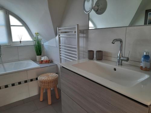 a white bathroom with a sink and a tub at Ferienhaus "Sturmmöwe" in Kramerhof