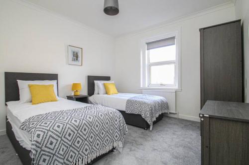 - une chambre avec 2 lits et une fenêtre dans l'établissement Tobago St Apartment, Greenock, à Greenock