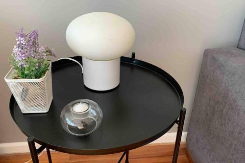 Una mesa negra con una lámpara y flores. en Charming and Comfortable Studio in Palermo en Buenos Aires