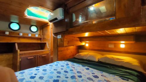 een slaapkamer met een bed in een boot bij Camping Yoghi e Bubu in San Giacomo