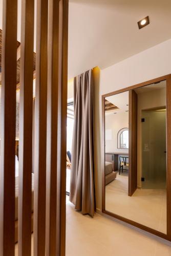 a large mirror in a room with a living room at Deep blue suites in Agios Prokopios