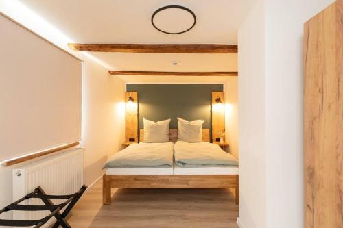 een slaapkamer met een bed met witte lakens en kussens bij Altstadthäuschen in Goslar