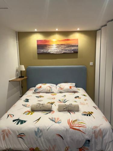 ein Schlafzimmer mit einem großen Bett und einem Gemälde an der Wand in der Unterkunft Au doux refuge 