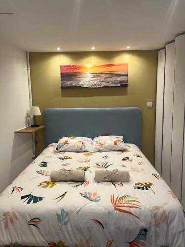 a bedroom with a large bed with a painting on the wall at Au doux refuge in Drouvin-les-Marais
