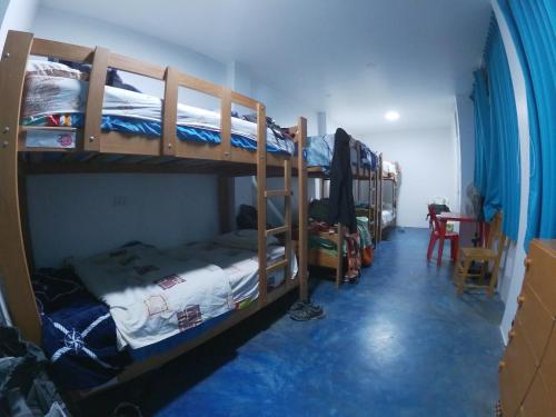 a room with two bunk beds and a table at Nanasqa Hostel en Nasca / Nazca in Nazca