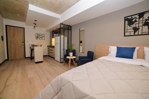 a bedroom with a large bed and a desk at Distrito A by Fma Coliving in Salta