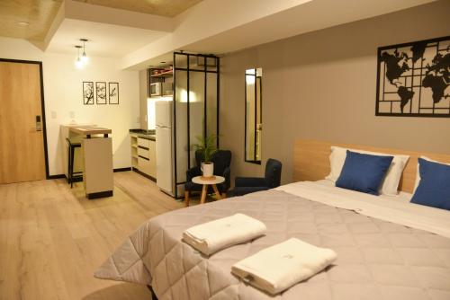 1 dormitorio con 1 cama grande y 2 toallas. en Distrito A FMA-Coliving en Salta