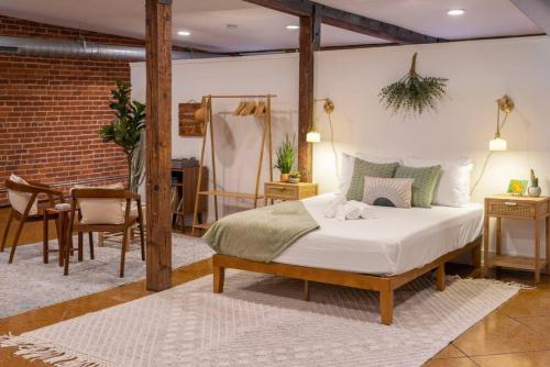 een slaapkamer met een bed en een tafel en stoelen bij Deluxe 3BR Loft Walkable to Everything Downtown in Cincinnati