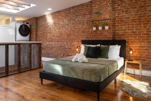 a bedroom with a bed and a brick wall at Stunning Loft in the heart of OTR in Cincinnati