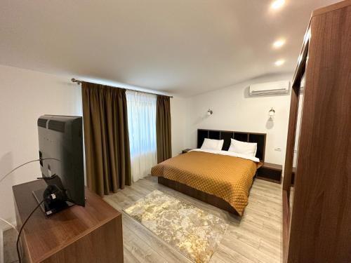 a bedroom with a bed and a flat screen tv at ZIM Family Airport in Otopeni