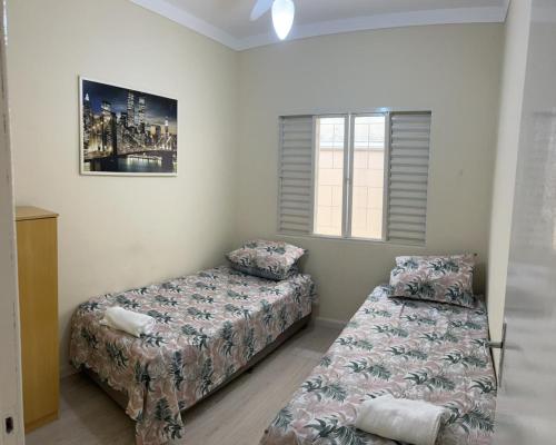 1 dormitorio con 2 camas y ventana en Casa incrível com 2 quartos e estacionamento incluso, en Maringá
