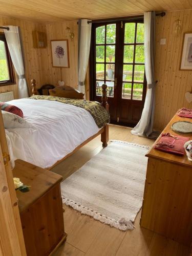 a bedroom with a bed and a large window at Martha's retreat in Wimborne Minster