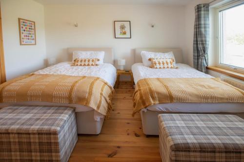 a room with two beds and two ottomans at Cuillich Mill Bed and Breakfast in the Highlands in Alness