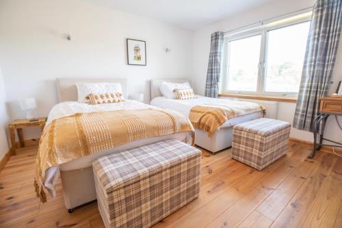 a bedroom with two beds and a window at Cuillich Mill Bed and Breakfast in the Highlands in Alness