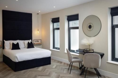 Five Apartments في بلاكبول: غرفة نوم مع سرير ومكتب مع كرسي