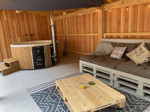 Cette chambre comprend un canapé et une table. dans l'établissement Les Ecuries de la Barre, à Mosnes