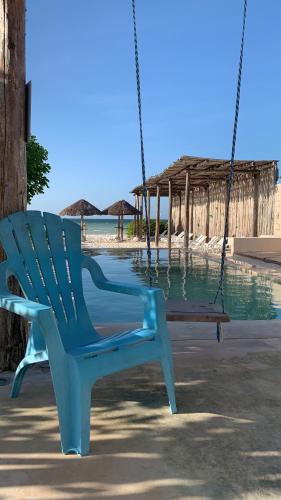 uma cadeira de baloiço azul em frente a uma praia em Telchac Villa de 3 pisos con club playa em Telchac Puerto