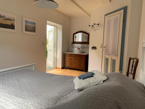 a bedroom with a bed and a dresser and a mirror at Historische Reetdach-Kate in Dannewerk