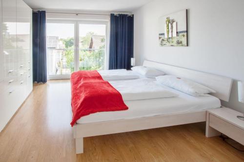 Traum-Ferienwohnung Alpenblick في باد ايبلنغ: غرفة نوم مع سرير مع بطانية حمراء عليه