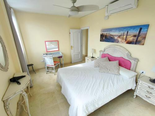 a bedroom with a white bed and a piano at Terraza del Atlántico, un oasis en la ciudad in Santa Cruz de Tenerife