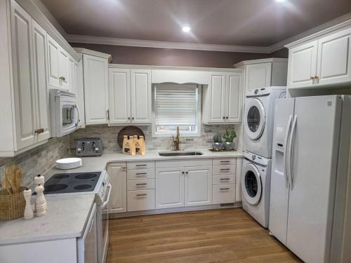- une cuisine blanche avec des appareils électroménagers et des armoires blanches dans l'établissement Comfy 2-BR Newly Renovated Abode in Fayetteville, à Fayetteville