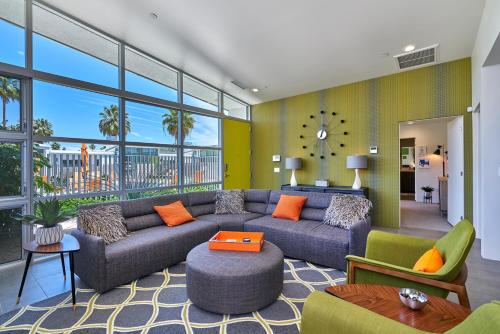 a living room with a blue couch and orange pillows at Sophia Oasis Luxe 2BR Condo with Mountain Views in Palm Springs