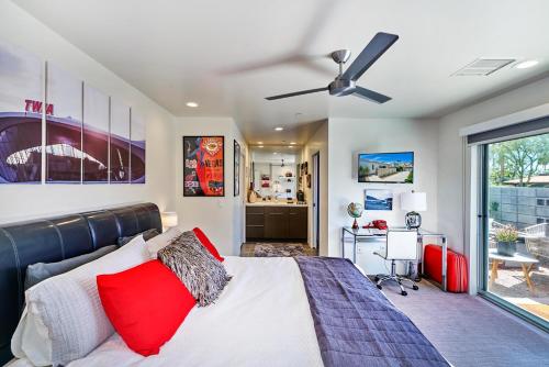 a bedroom with a bed with red pillows and a ceiling fan at Sophia Oasis Luxe 2BR Condo with Mountain Views in Palm Springs