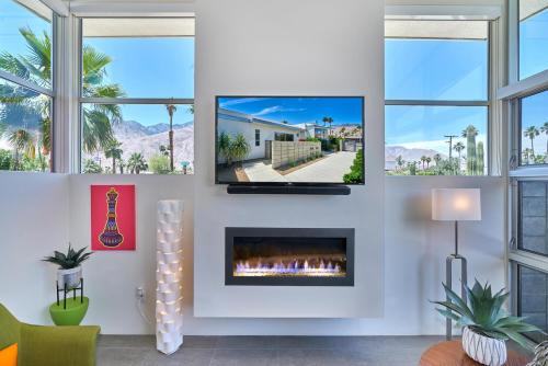 a living room with a fireplace and a tv at Sophia Oasis Luxe 2BR Condo with Mountain Views in Palm Springs