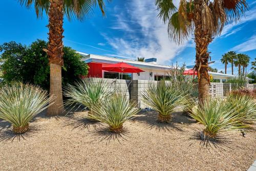 a group of palm trees in front of a house at Sophia Oasis Luxe 2BR Condo with Mountain Views in Palm Springs