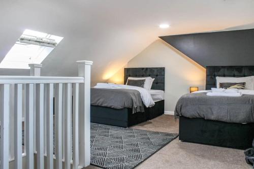 een slaapkamer met 2 bedden en een dakraam bij Private driveway - close to Warwick Racecourse & Warwick Castle!! in Warwick