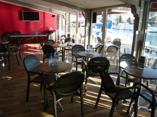 a row of tables and chairs in a restaurant at Hôtel Port Beach in Gruissan