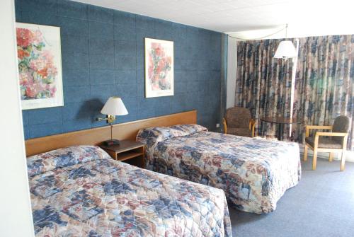 a hotel room with two beds and a table at The Inn At Lock Seven in Thorold