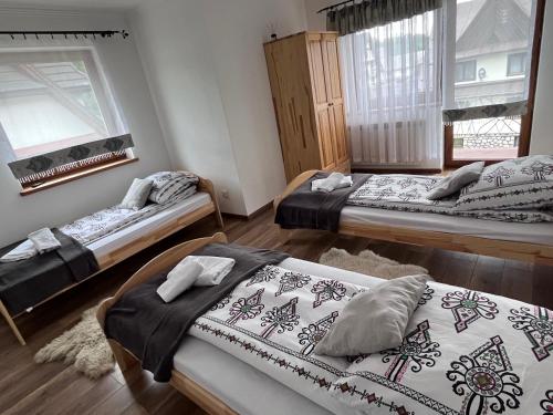 a room with three beds in a room at Apartament u Jarosza in Poronin