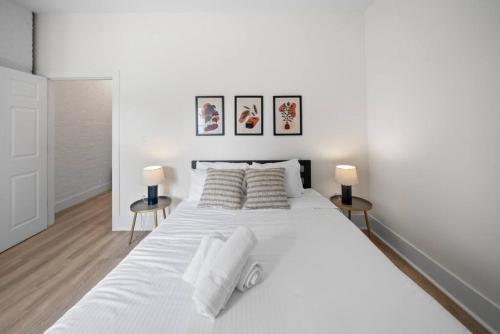 Un dormitorio blanco con una gran cama blanca con dos lámparas. en Spacious and Modern 3BR near Downtown and Walnut Hills, en Cincinnati