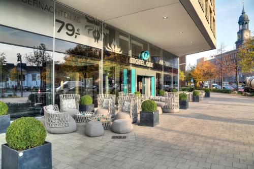 a group of chairs sitting outside of a store at Motel One Hamburg am Michel in Hamburg