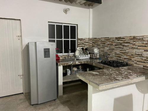 uma cozinha com um frigorífico de aço inoxidável e um balcão em House Balcon del atardecer em Guachaca