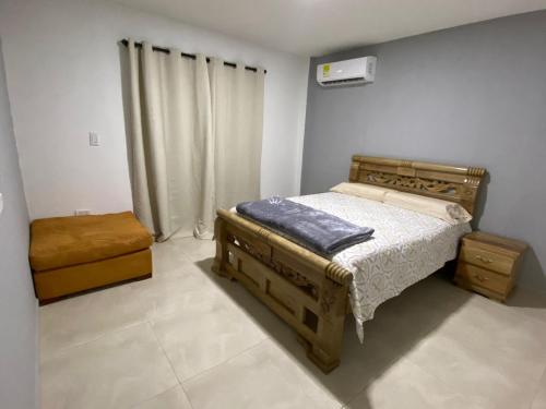 um quarto com uma cama e uma mesa de cabeceira e uma cama sidx sidx sidx em House Balcon del atardecer em Guachaca
