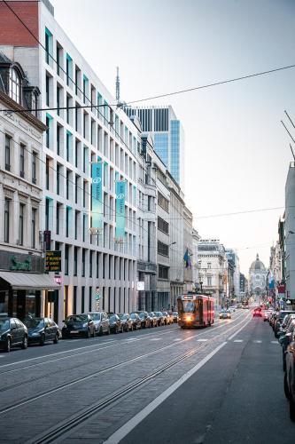 a bus driving down a city street with cars at Motel One Brussels in Brussels