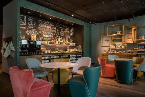 a restaurant with tables and chairs and a counter at Motel One Hannover-Oper in Hannover