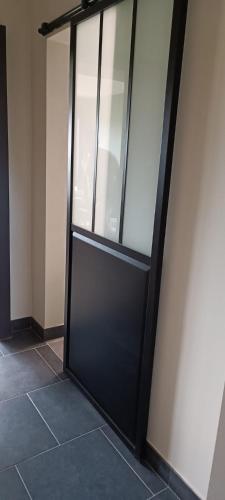 a sliding glass door in a room with a tile floor at Les roses d'Olga in Aubechies