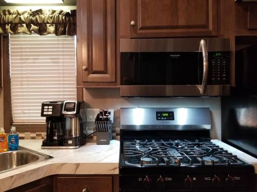 a kitchen with a stove and a microwave at Tiny home with hammock loft BBQ and yard in Phenix City