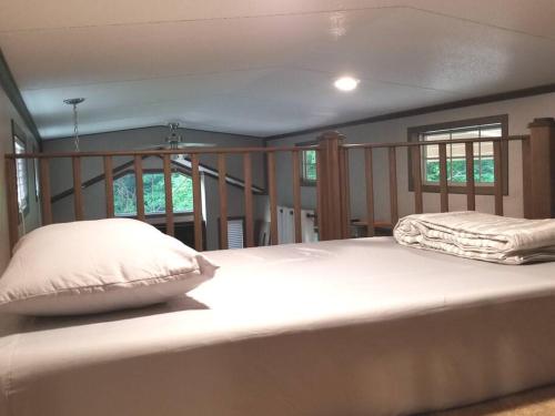 a large white bed in a room with windows at Tiny home with hammock loft BBQ and yard in Phenix City