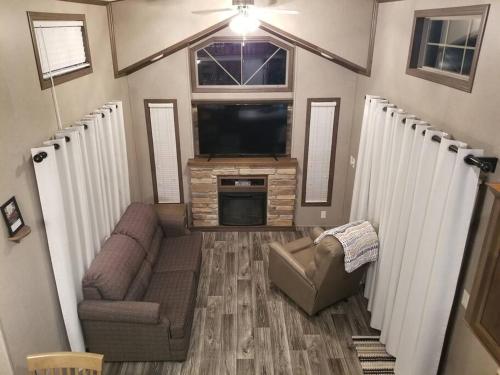 a small living room with a tv and a couch and a televisionicter at Tiny home with hammock loft BBQ and yard in Phenix City