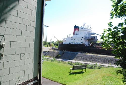 a bench in front of a ship in a field at The Inn At Lock Seven in Thorold