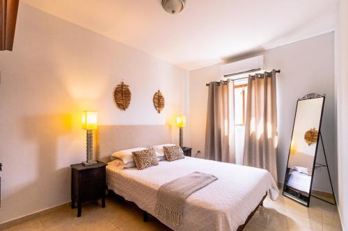 - une chambre avec un lit et un miroir dans l'établissement Felicidad 30, à Oranjestad