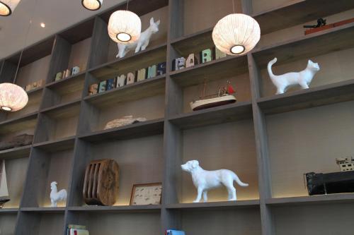 une étagère remplie de figurines de chats blancs et de lumières dans l'établissement Motel One Bremen, à Brême