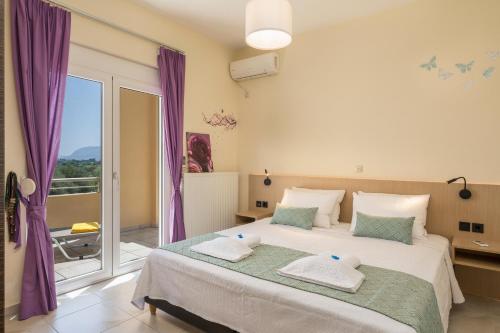 a bedroom with a large bed with purple curtains at AnnaBoutique Villa Beach, Heated Private Pool & BBQ in Kato Daratso