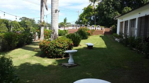 a yard with two bird baths in the grass at Highpoint Island Villas in Ocho Rios